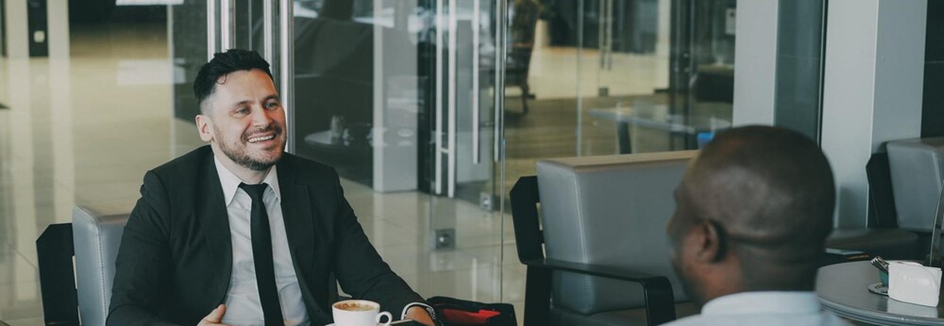 Recruteur posant des questions d'entretien à un commercial B2B en salle de réunion
