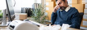 Chef d'entreprise PME analysant un dossier d'appel d'offres public complexe
