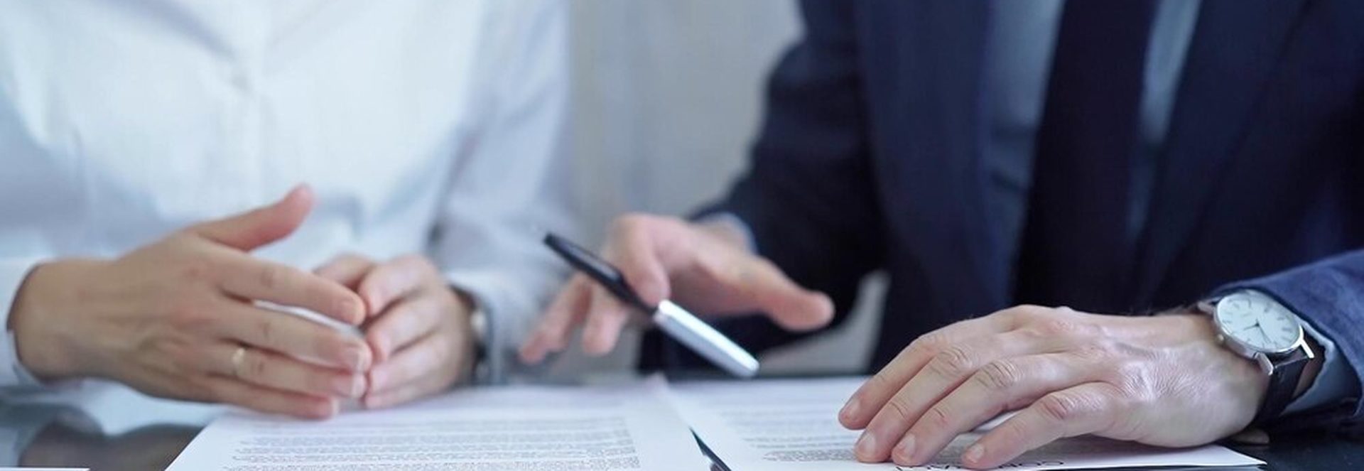 Deux professionnels analysant un contrat avec une loupe sur une clause d'indexation