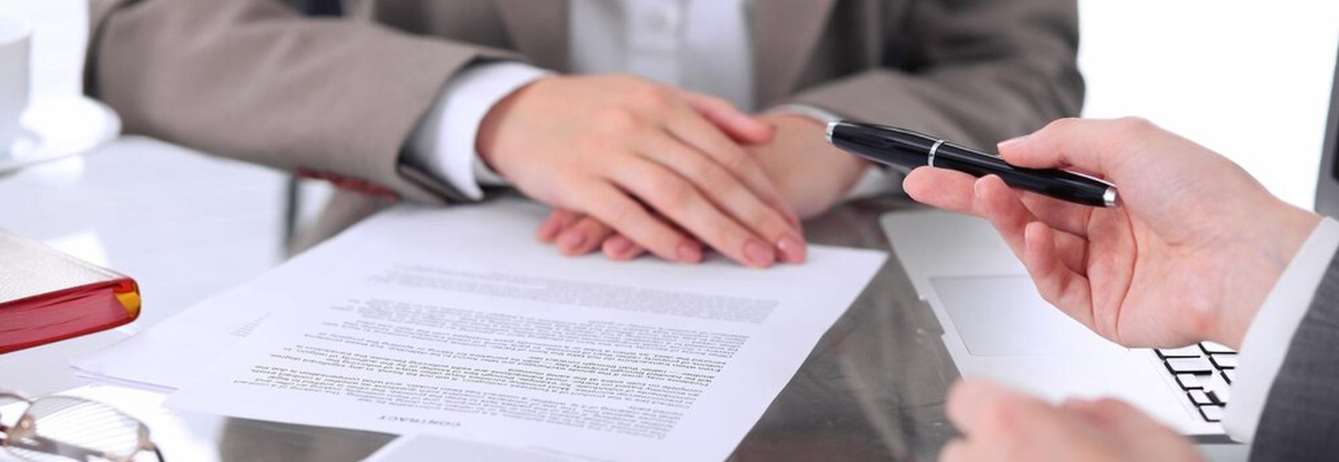 Signature d'un contrat commercial avec une loupe sur une clause juridique