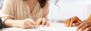 Deux professionnels signant un contrat B2B avec une clause de révision de prix