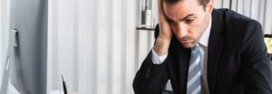 Dirigeant stressé examinant des factures et un calculateur financier