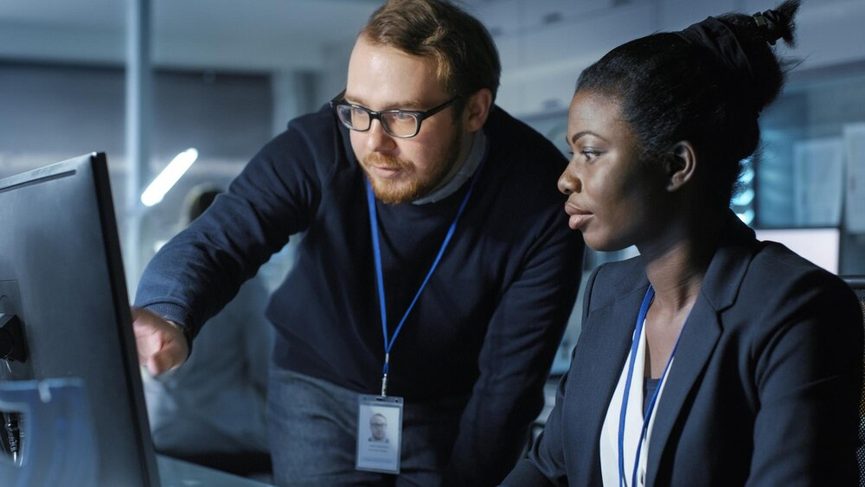 Vue rapprochée d'un professionnel RH analysant des documents confidentiels sur un écran sécurisé