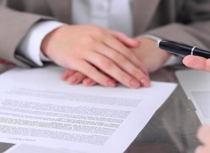 Signature d'un contrat commercial avec une loupe sur une clause juridique