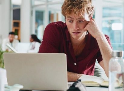 Salarié désengagé regardant son ordinateur dans un bureau vide