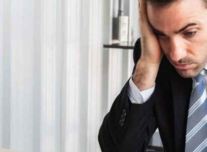 Dirigeant stressé examinant des factures et un calculateur financier