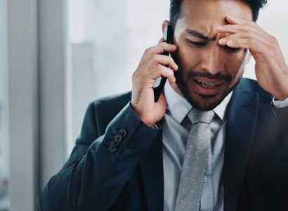 Homme d'affaires frustré regardant son téléphone sans réponse